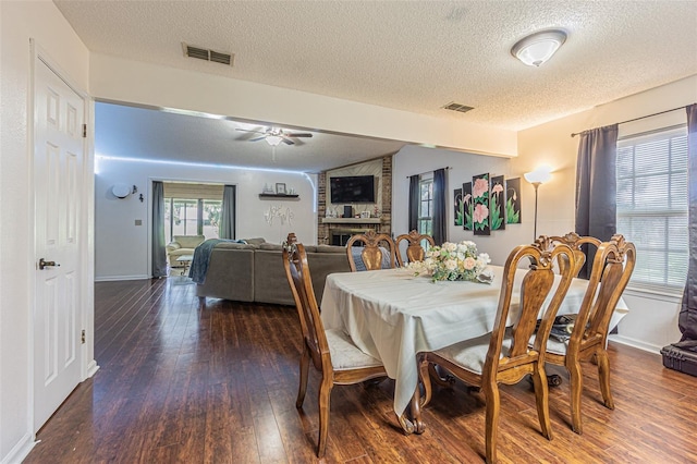 35058 Whispering Oaks Blvd, Dade City, FL 33523 - dining area with a textured ceiling, hardwood / wood-style floors, a ceiling fan, baseboards, and a fireplace