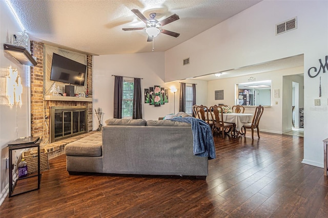 35058 Whispering Oaks Blvd, Dade City, FL 33523 - living area featuring vaulted ceiling, ceiling fan, a textured ceiling, a fireplace, and dark wood-type flooring