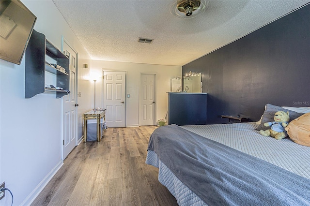 35058 Whispering Oaks Blvd, Dade City, FL 33523 - bedroom with wood finished floors, a textured ceiling, and baseboards