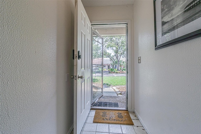 35058 Whispering Oaks Blvd, Dade City, FL 33523 - doorway to outside with tile patterned floors, a textured wall, and baseboards