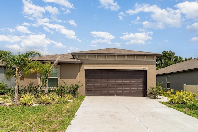 view of front of house with stucco siding, concrete driveway, an attached garage, and a shingled roof