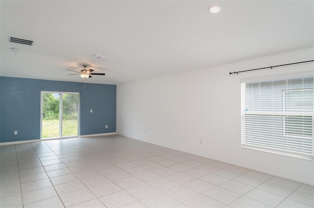 spare room featuring a ceiling fan, baseboards, and light tile patterned floors