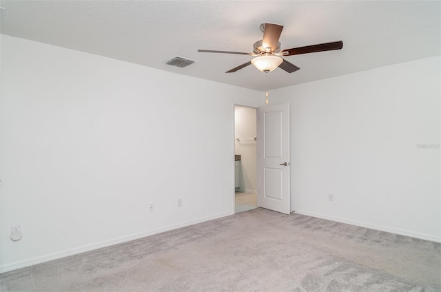 unfurnished room featuring a ceiling fan, light colored carpet, and baseboards