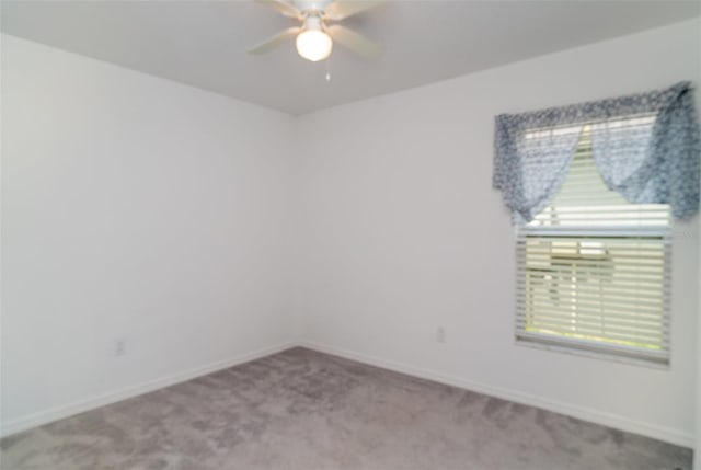 spare room with carpet floors, ceiling fan, and baseboards