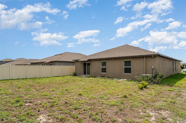 rear view of house featuring stucco siding