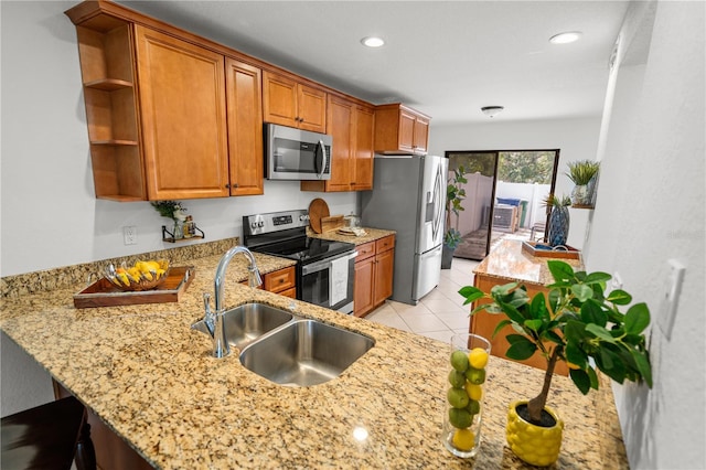 108 Biscayne Ave Unit B, Tampa, FL 33606 - kitchen with stainless steel appliances, a sink, brown cabinetry, open shelves, and light stone counters