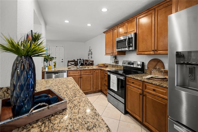 108 Biscayne Ave Unit B, Tampa, FL 33606 - kitchen with appliances with stainless steel finishes, a sink, brown cabinets, light stone counters, and recessed lighting