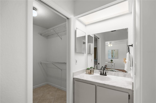 108 Biscayne Ave Unit B, Tampa, FL 33606 - bathroom with a spacious closet, tile patterned floors, vanity, and a ceiling fan