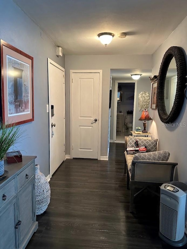 corridor with dark wood-style flooring and baseboards