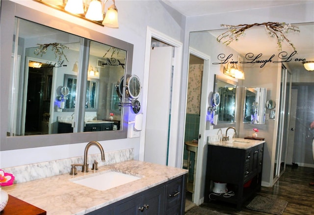 full bathroom featuring two vanities and wood finished floors