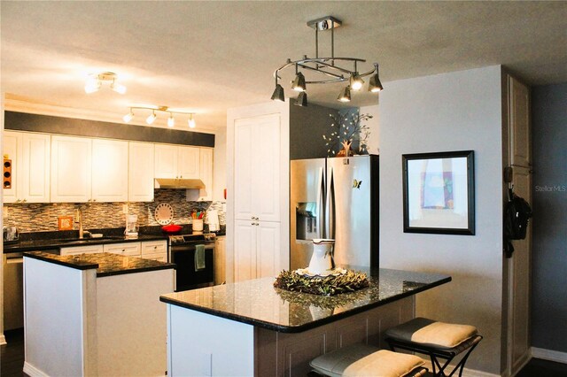 7200 Sunshine Skyway Ln S Unit 2E, Saint Petersburg, FL 33711 - kitchen featuring appliances with stainless steel finishes, a kitchen island, tasteful backsplash, a sink, and white cabinets