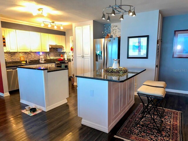 7200 Sunshine Skyway Ln S Unit 2E, Saint Petersburg, FL 33711 - kitchen with appliances with stainless steel finishes, a center island, dark wood-style flooring, and decorative backsplash