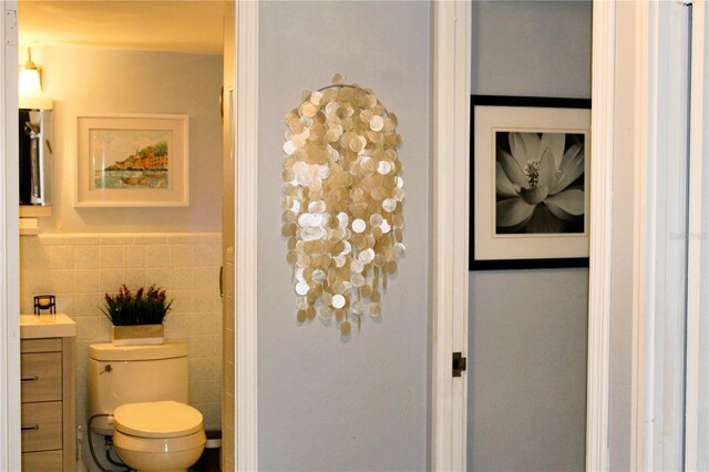 7200 Sunshine Skyway Ln S Unit 2E, Saint Petersburg, FL 33711 - bathroom featuring toilet, vanity, and tile walls