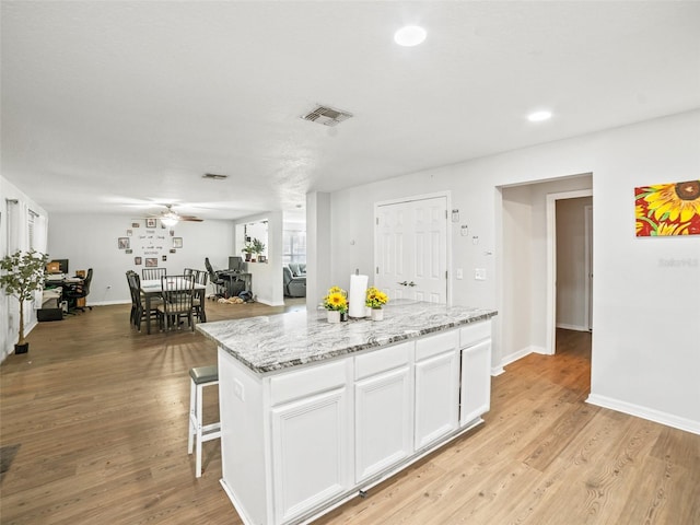 kitchen with a ceiling fan, white cabinetry, light wood-style flooring, baseboards, and recessed lighting
