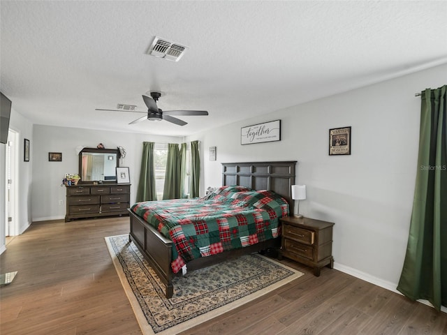 bedroom with baseboards, wood finished floors, ceiling fan, and a textured ceiling