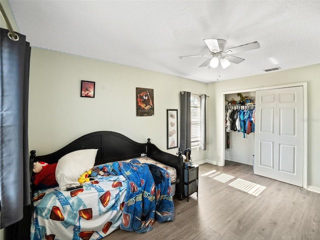 bedroom featuring wood finished floors, a closet, ceiling fan, and baseboards