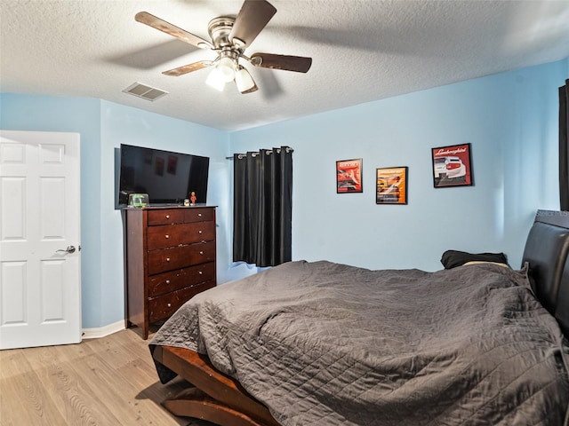 bedroom with light wood finished floors, a textured ceiling, and ceiling fan