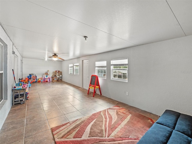 game room with tile patterned floors and ceiling fan