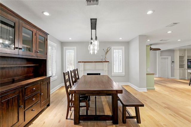 493 Lucerne Ave, Tampa, FL 33606 - dining area with baseboards, a fireplace, light wood-type flooring, and recessed lighting