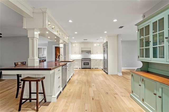 493 Lucerne Ave, Tampa, FL 33606 - kitchen featuring high quality appliances, wooden counters, green cabinets, light wood-type flooring, and recessed lighting