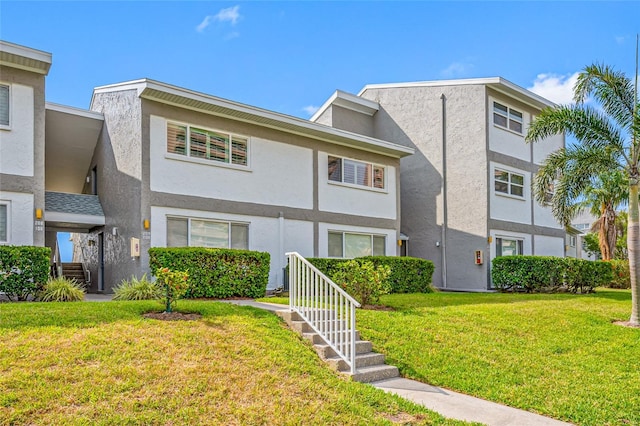 1351 Gulf Blvd Unit 209, Clearwater Beach, FL 33767 - view of property with stucco siding and a front lawn