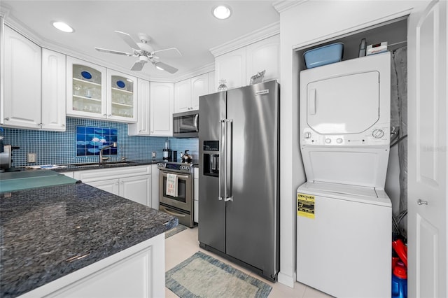1351 Gulf Blvd Unit 209, Clearwater Beach, FL 33767 - kitchen with stainless steel appliances, estacked washer and dryer, a ceiling fan, white cabinetry, and recessed lighting