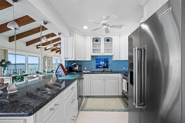 1351 Gulf Blvd Unit 209, Clearwater Beach, FL 33767 - kitchen featuring appliances with stainless steel finishes, a ceiling fan, light tile patterned floors, white cabinets, and decorative backsplash