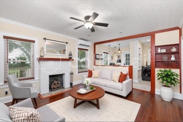 931 28th Ave N, Saint Petersburg, FL 33704 - living area with an AC wall unit, washer / clothes dryer, a fireplace, wood finished floors, and a textured ceiling