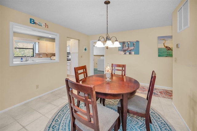 dining room featuring a chandelier, light tile patterned flooring, and baseboards