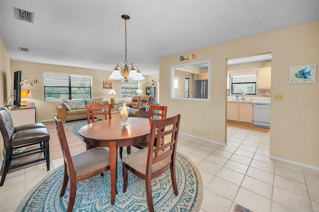 dining room with light tile patterned floors, a chandelier, and baseboards