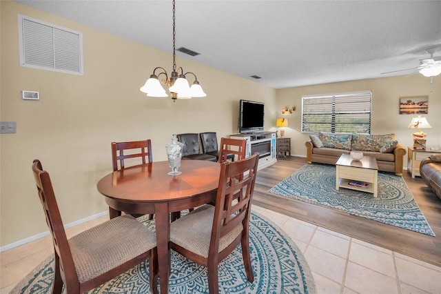 dining space featuring a chandelier, a ceiling fan, tile patterned flooring, and baseboards