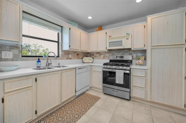 kitchen featuring white appliances, light brown cabinets, a sink, light countertops, and recessed lighting