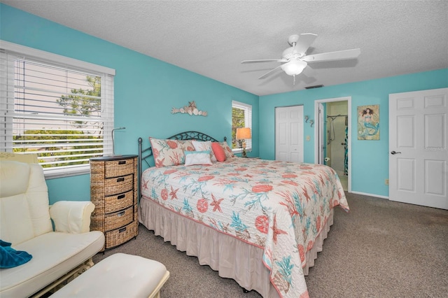 carpeted bedroom with a textured ceiling, a closet, ceiling fan, and ensuite bathroom
