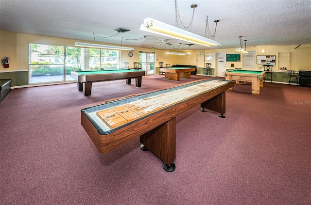 game room with dark colored carpet, billiards table, and a textured ceiling