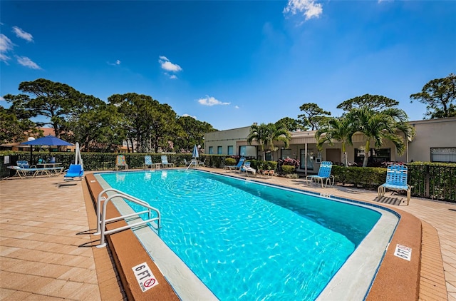 community pool with fence and a patio area
