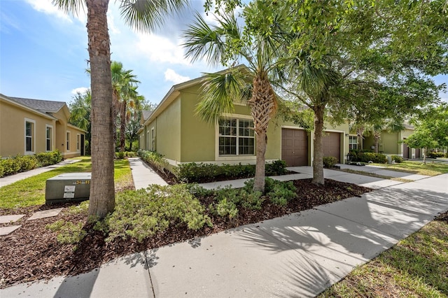view of front of property featuring concrete driveway, a garage, and stucco siding