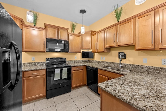 kitchen with black appliances, a sink, light tile patterned floors, and stone counters