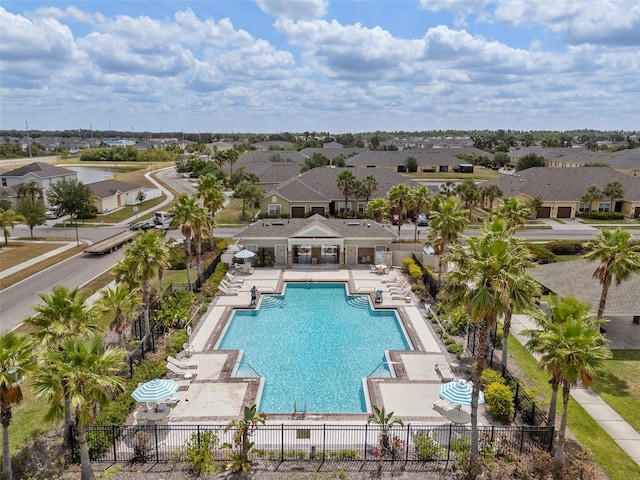 community pool with fence, a patio area, and a residential view
