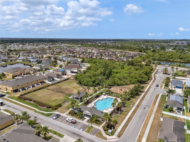 view of property location with nearby suburban area, a pool area, and a nearby body of water