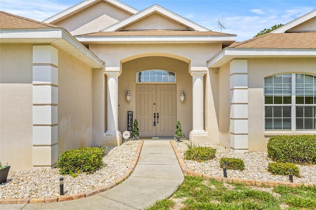 7206 River Country Dr, Weeki Wachee, FL 34607 - view of exterior entry with stucco siding and roof with shingles