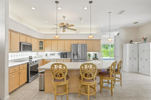 7206 River Country Dr, Weeki Wachee, FL 34607 - kitchen featuring appliances with stainless steel finishes, light brown cabinetry, light countertops, a spacious island, and recessed lighting