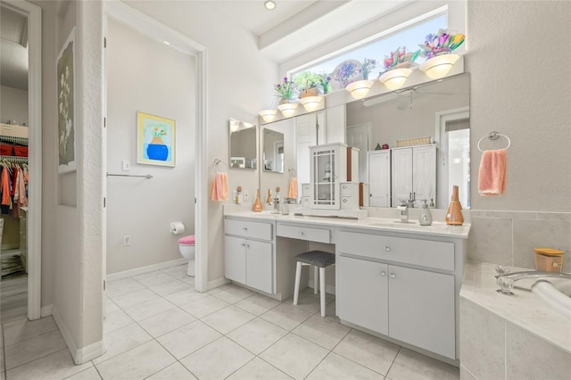 7206 River Country Dr, Weeki Wachee, FL 34607 - full bath featuring tile patterned floors, vanity, toilet, a garden tub, and a spacious closet