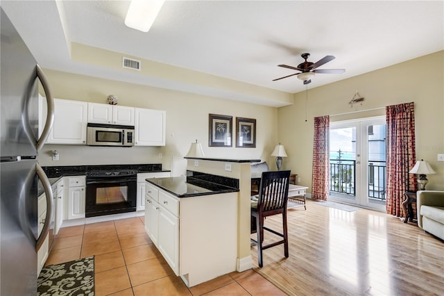 13235 Gulf Blvd Unit 402, Saint Petersburg, FL 33708 - kitchen featuring stainless steel appliances, a kitchen bar, white cabinetry, and a ceiling fan