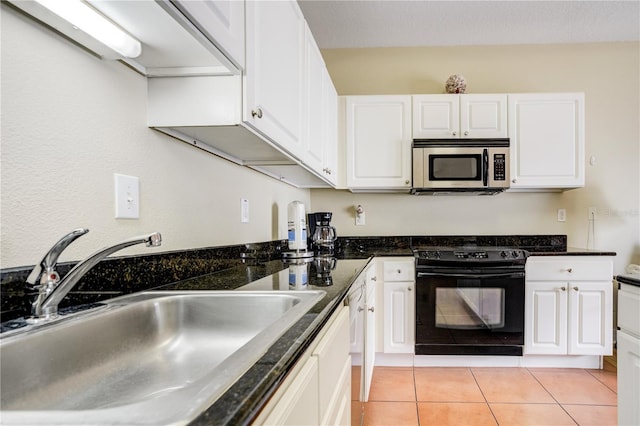 13235 Gulf Blvd Unit 402, Saint Petersburg, FL 33708 - kitchen with stainless steel microwave, black electric range oven, a sink, white cabinets, and light tile patterned flooring