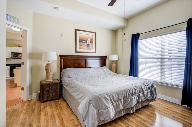 13235 Gulf Blvd Unit 402, Saint Petersburg, FL 33708 - bedroom with baseboards, light wood-style flooring, and ceiling fan