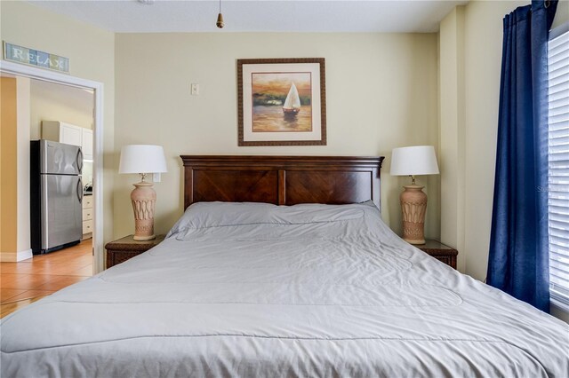 13235 Gulf Blvd Unit 402, Saint Petersburg, FL 33708 - bedroom featuring freestanding refrigerator, multiple windows, and light tile patterned floors
