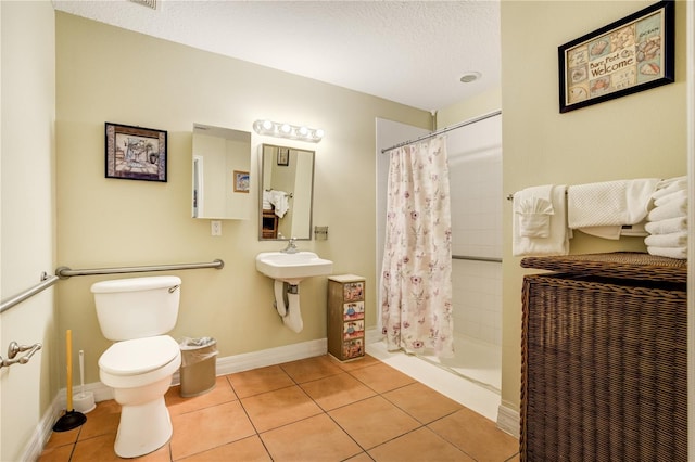 13235 Gulf Blvd Unit 402, Saint Petersburg, FL 33708 - bathroom with toilet, tile patterned floors, a shower stall, and a textured ceiling
