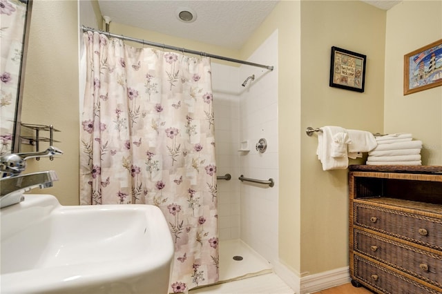 13235 Gulf Blvd Unit 402, Saint Petersburg, FL 33708 - bathroom featuring a sink, a shower stall, and a textured ceiling