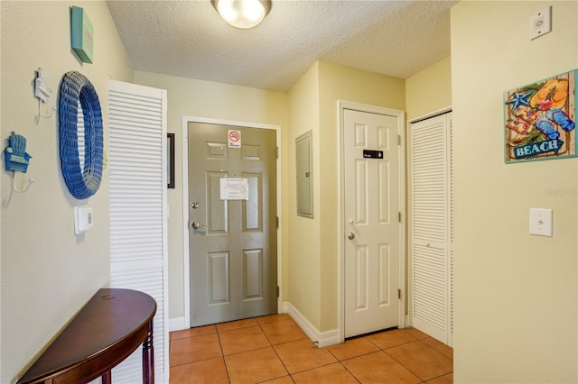 13235 Gulf Blvd Unit 402, Saint Petersburg, FL 33708 - foyer with light tile patterned floors, a textured ceiling, electric panel, and baseboards