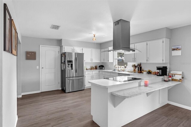 4727 Wales St, Lake Wales, FL 33859 - kitchen with stainless steel fridge with ice dispenser, island range hood, black electric cooktop, a peninsula, and light countertops